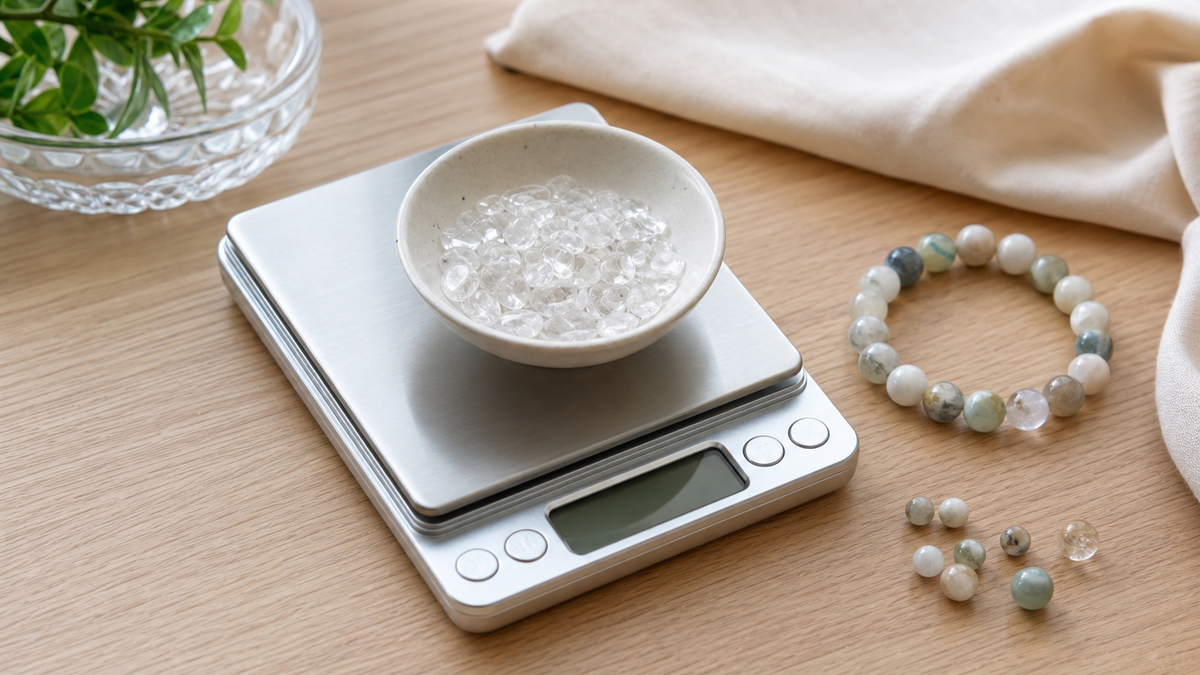 デジタルスケールに水晶さざれ石の小皿を置き、横に天然石ブレスレットとビーズを並べた様子